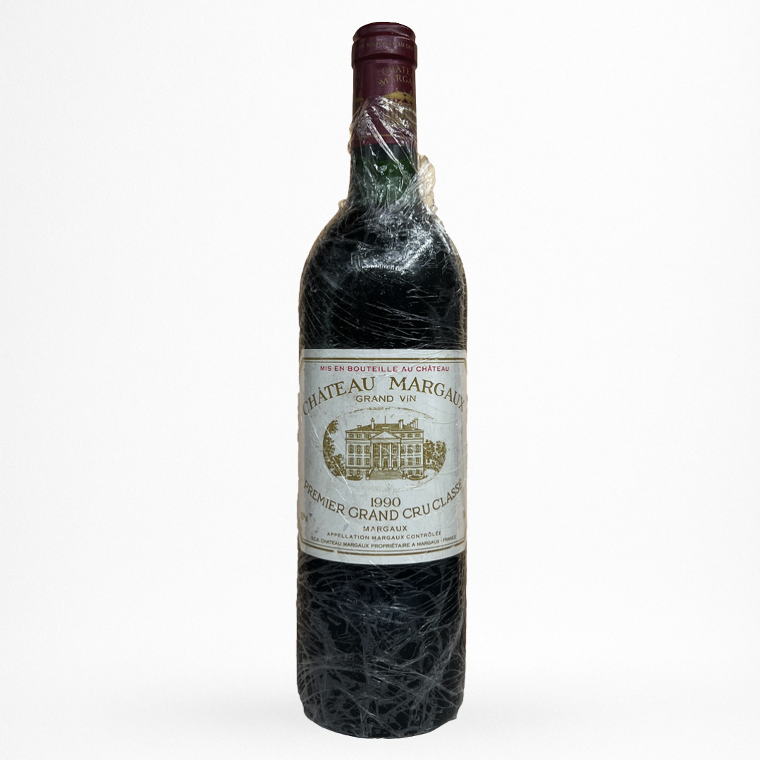 Bouteille de vin rouge Château Margaux 1990, verre sombre partiellement filmé, étiquette crème, capsule bordeaux, fond blanc
