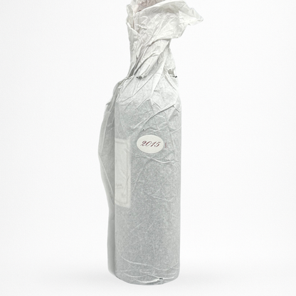 Château Le Pin 2015 – Pomerol, bouteille 75 cl emballée dans un papier de soie avec pastille “2015”, vue contre-étiquette sur fond blanc.