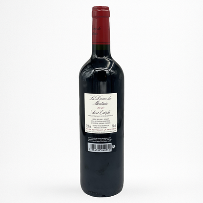 Bouteille de vin rouge La Dame de Montrose 2011 Saint-Estèphe, contre étiquette blanche, capsule bordeaux, verre sombre sur fond blanc